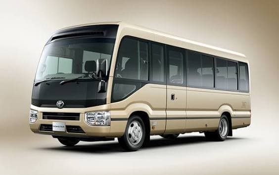 Toyota Coaster Minibus · 2025/2026 - 20 passengers, 15 luggage capacity. Twenty reclining seats with a PA system, so a group leader can address everyone without shouting. Built for agency groups moving on a schedule.